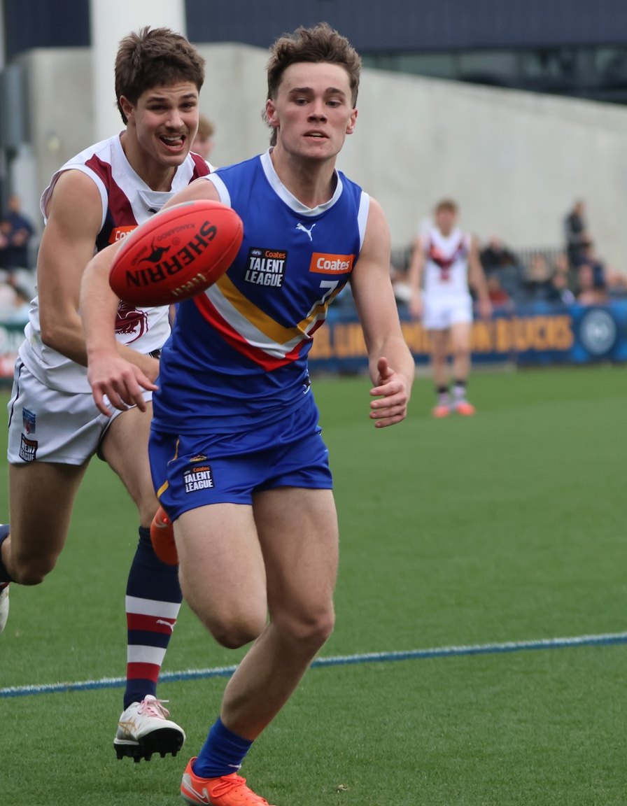 An AFL ball in play during a night match